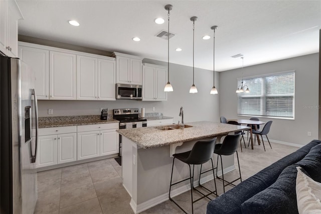 kitchen featuring sink, white cabinetry, decorative light fixtures, and stainless steel appliances