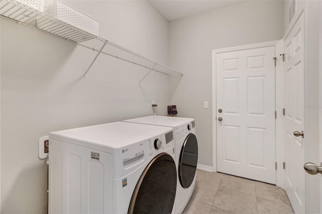 laundry room featuring light tile patterned flooring and separate washer and dryer