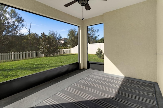 unfurnished sunroom with ceiling fan