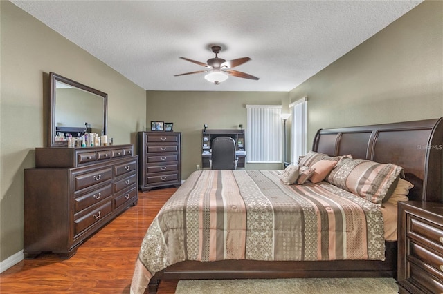 bedroom featuring dark wood-type flooring, ceiling fan, and a textured ceiling