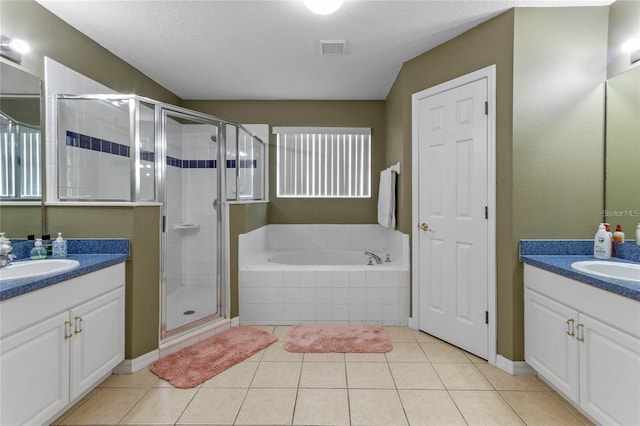 bathroom with vanity, independent shower and bath, a textured ceiling, and tile patterned flooring