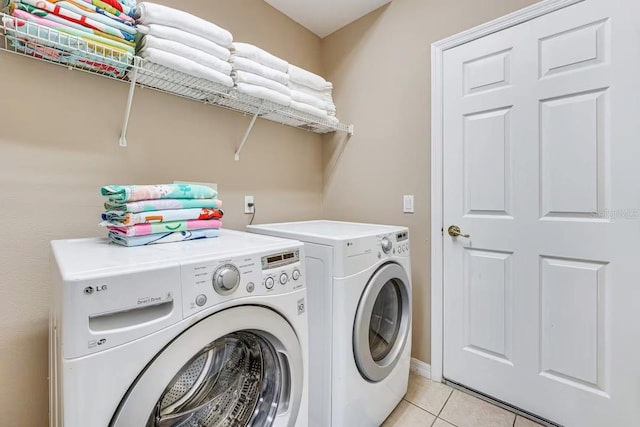 washroom with independent washer and dryer and light tile patterned floors