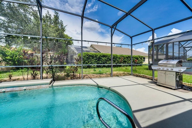 view of swimming pool with area for grilling, a patio area, and a lanai