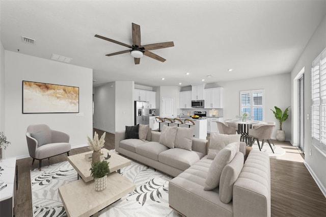 living room with ceiling fan and light hardwood / wood-style floors