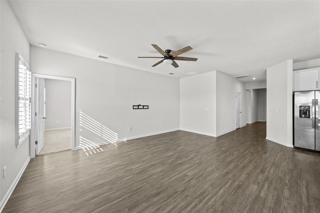 unfurnished living room with dark hardwood / wood-style flooring and ceiling fan