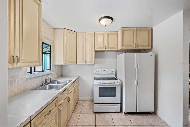 kitchen with tasteful backsplash, white appliances, sink, and light tile patterned floors