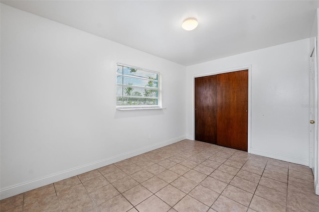 unfurnished bedroom featuring a closet and light tile patterned floors