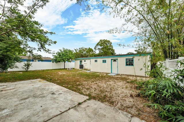 rear view of property featuring a lawn and a patio area