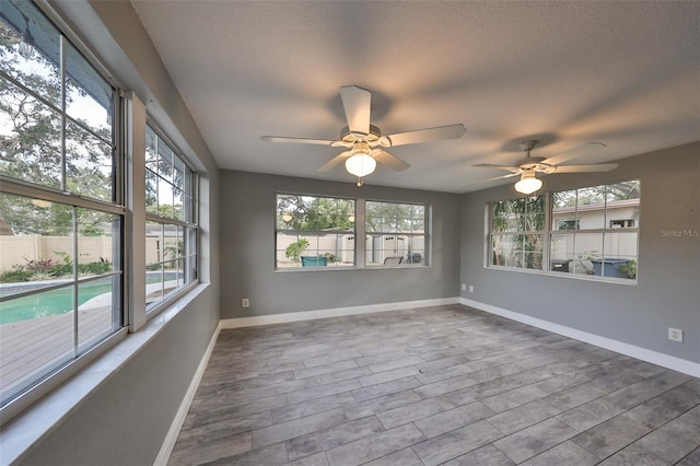 spare room with a textured ceiling, wood-type flooring, and ceiling fan