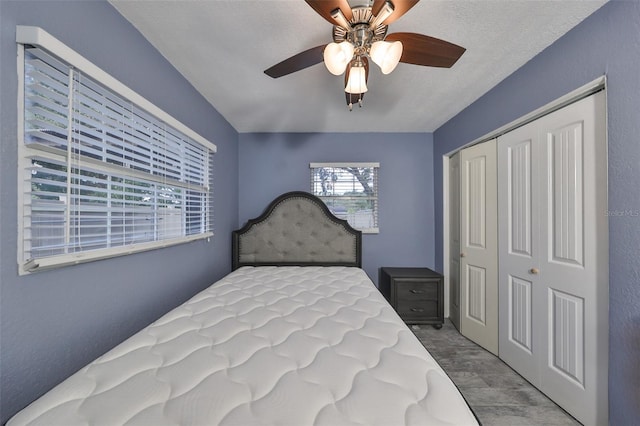 bedroom featuring a closet, ceiling fan, and a textured ceiling