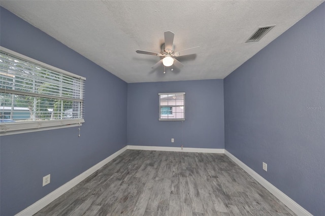 spare room with a textured ceiling, wood-type flooring, and ceiling fan