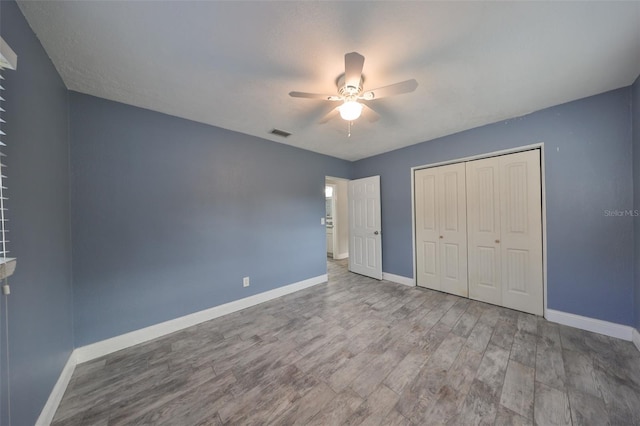 unfurnished bedroom featuring a closet, ceiling fan, and hardwood / wood-style flooring