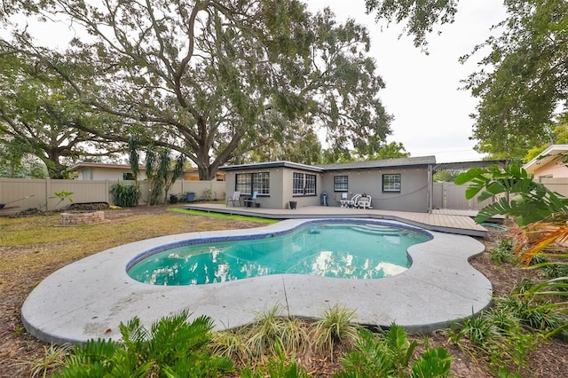 view of swimming pool featuring a fenced backyard, a fenced in pool, a patio area, and a wooden deck