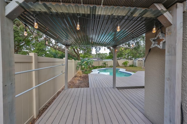 deck with a storage shed and a fenced in pool