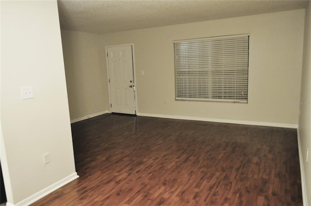 spare room with dark hardwood / wood-style flooring and a textured ceiling