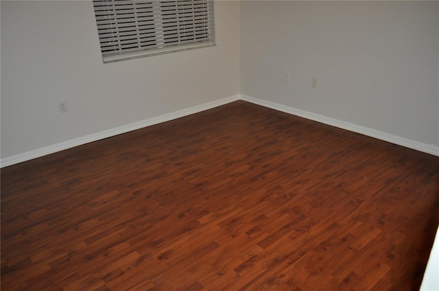 empty room with dark hardwood / wood-style flooring