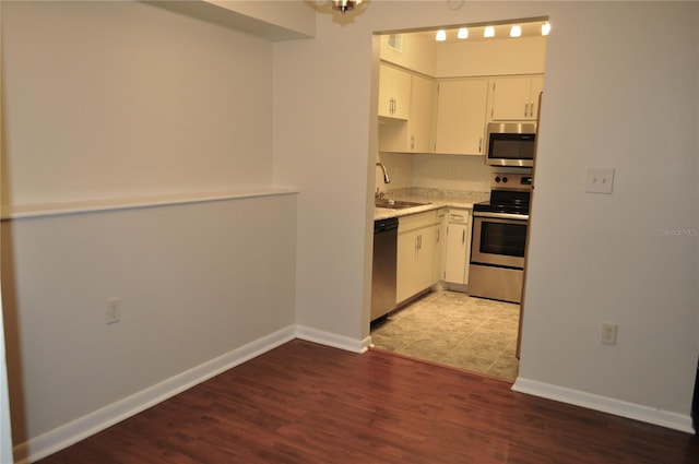 kitchen featuring white cabinets, light hardwood / wood-style floors, sink, and appliances with stainless steel finishes