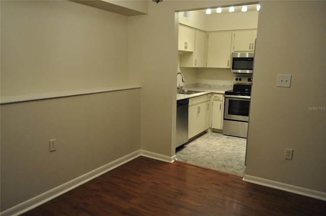 kitchen featuring white cabinets, hardwood / wood-style flooring, sink, and appliances with stainless steel finishes