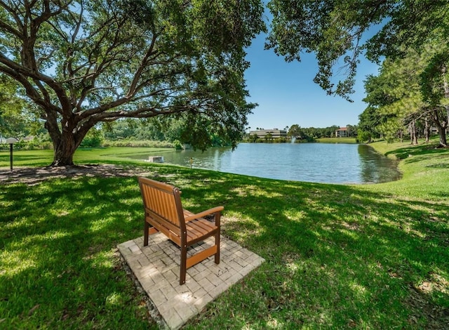 surrounding community with a water view and a yard