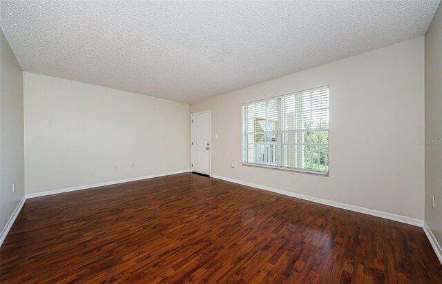2690 Coral Landings Blvd Unit 722, Palm Harbor, FL 34684 - spare room featuring dark wood-type flooring, baseboards, and a textured ceiling