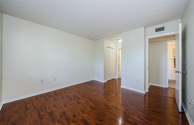 2690 Coral Landings Blvd Unit 722, Palm Harbor, FL 34684 - empty room with wood finished floors, baseboards, and a textured ceiling