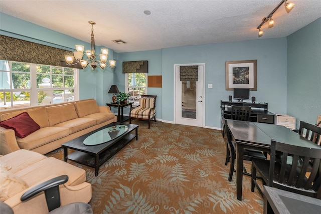 2690 Coral Landings Blvd Unit 722, Palm Harbor, FL 34684 - living area with a chandelier, carpet flooring, a textured ceiling, and baseboards