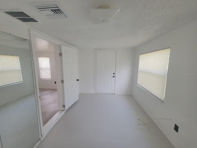 unfurnished room featuring a textured ceiling