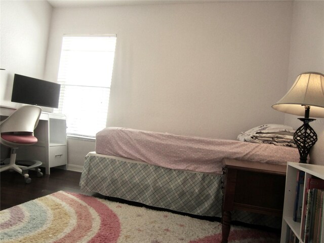 bedroom featuring dark hardwood / wood-style flooring and multiple windows