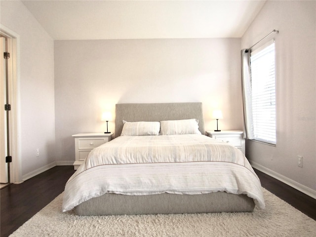 bedroom with multiple windows and dark hardwood / wood-style flooring