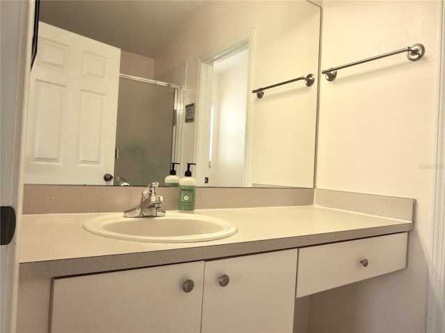 bathroom featuring vanity and a shower with door