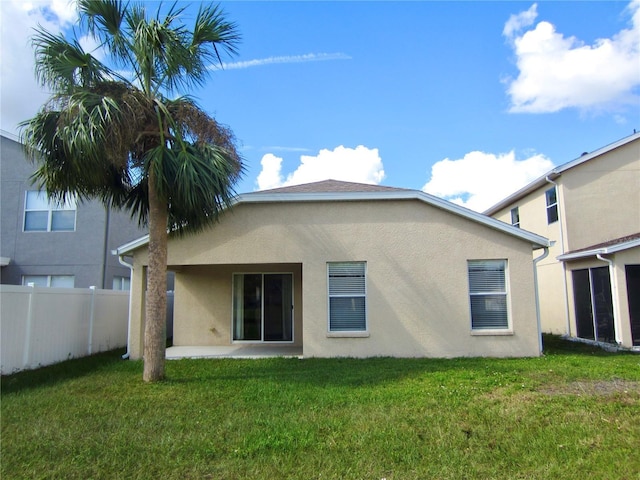 rear view of property featuring a lawn and a patio