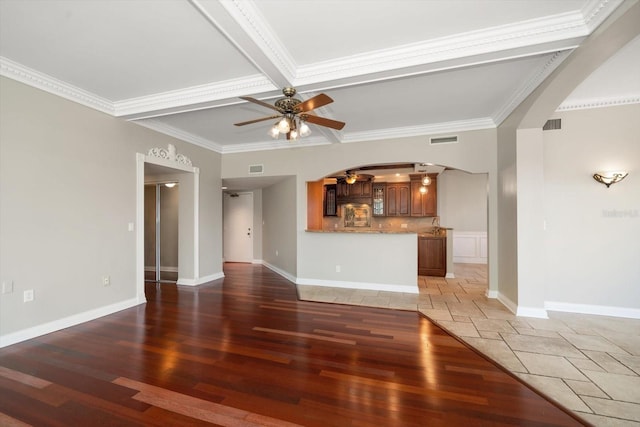 unfurnished living room featuring crown molding, beamed ceiling, dark hardwood / wood-style flooring, and ceiling fan