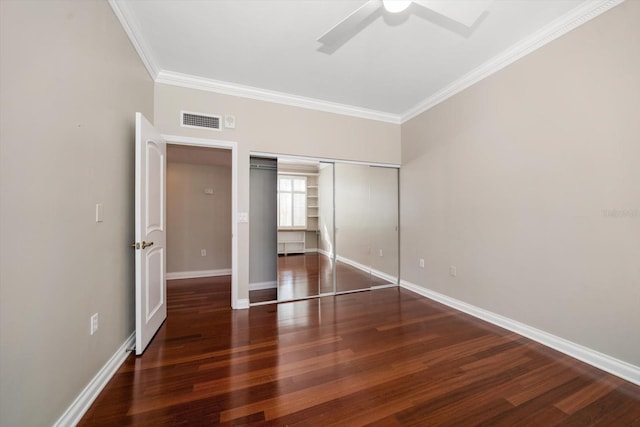 unfurnished bedroom with a closet, ceiling fan, crown molding, and dark hardwood / wood-style floors