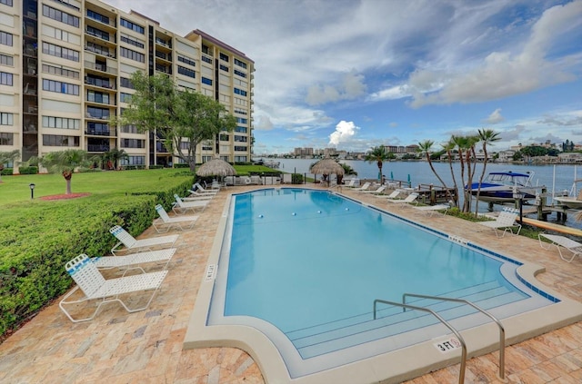 view of swimming pool with a yard and a water view