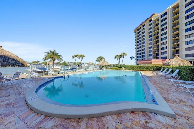 view of pool with a patio area and a water view