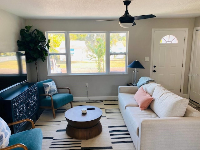 living room with a textured ceiling, a healthy amount of sunlight, and ceiling fan