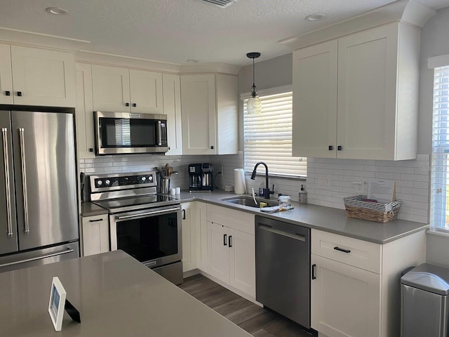 kitchen with stainless steel appliances, sink, plenty of natural light, and white cabinets