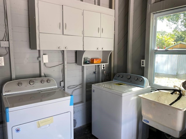 laundry room featuring sink, washer and dryer, and cabinets