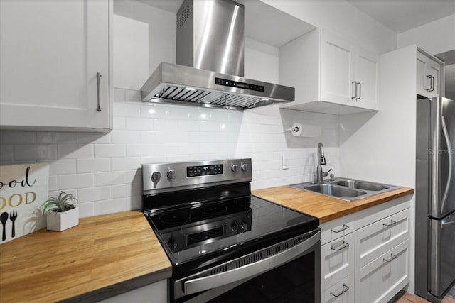 kitchen with butcher block counters, stainless steel appliances, wall chimney exhaust hood, and sink