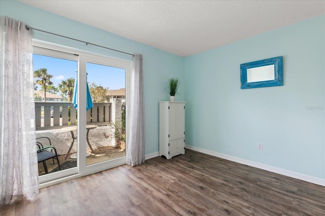 empty room with a textured ceiling and hardwood / wood-style flooring