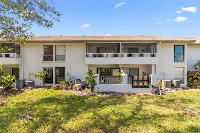 rear view of property featuring central air condition unit, a yard, a patio, and a balcony