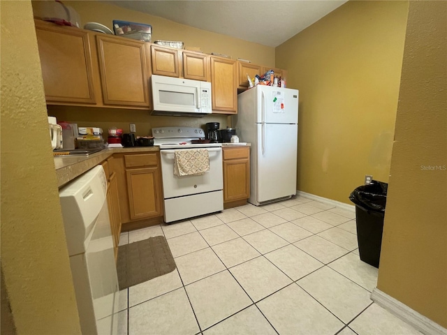 kitchen featuring light tile patterned flooring and white appliances