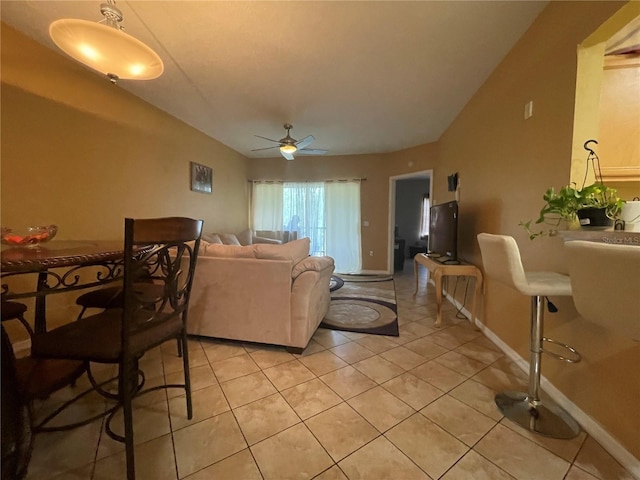 living room with vaulted ceiling, light tile patterned floors, and ceiling fan