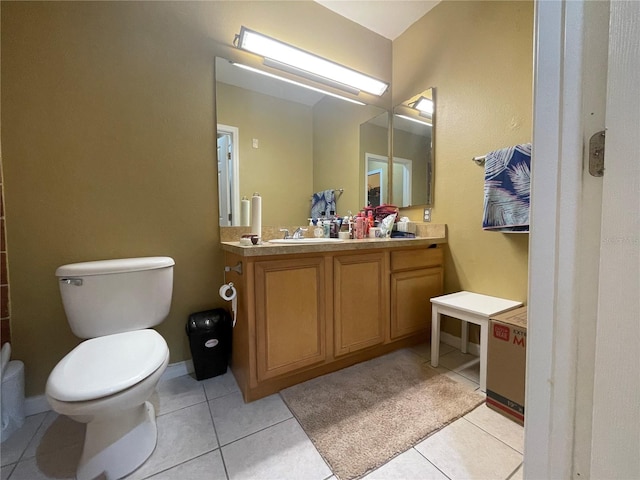 bathroom with toilet, vanity, and tile patterned floors