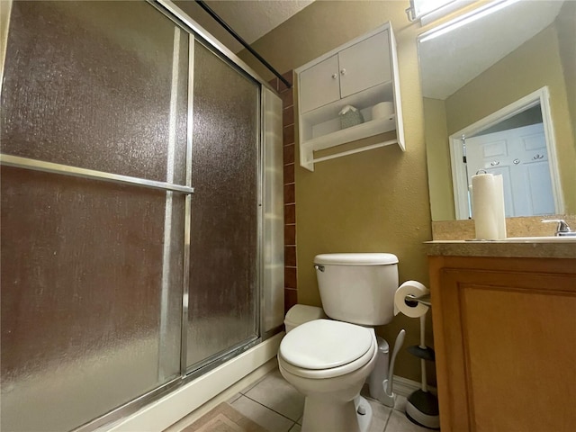 bathroom with toilet, walk in shower, vanity, and tile patterned floors