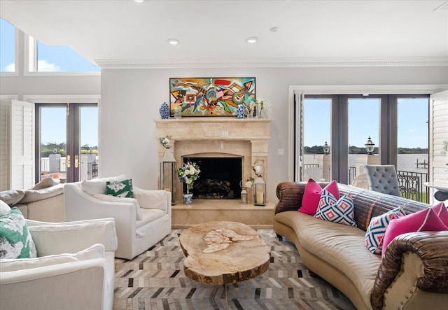 living room with crown molding, french doors, and a fireplace