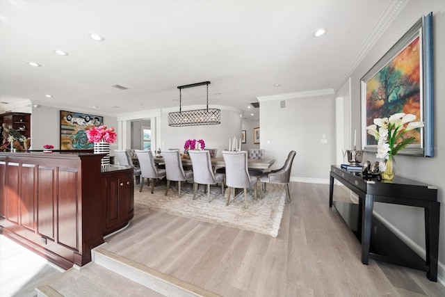 dining room featuring ornamental molding, recessed lighting, and light wood-style flooring