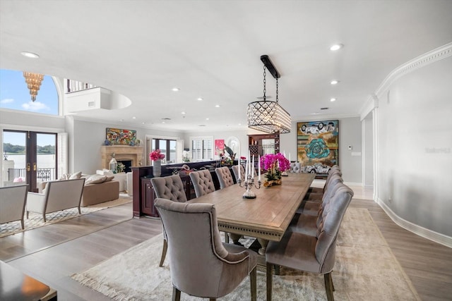 dining area with light wood finished floors, a fireplace, a wealth of natural light, and french doors