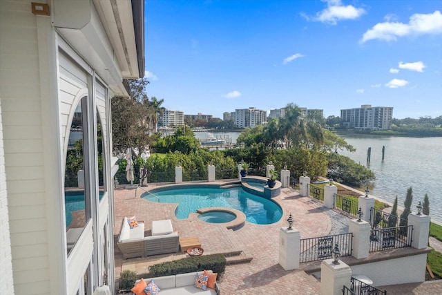 view of pool featuring a patio, a water view, fence, a city view, and a pool with connected hot tub