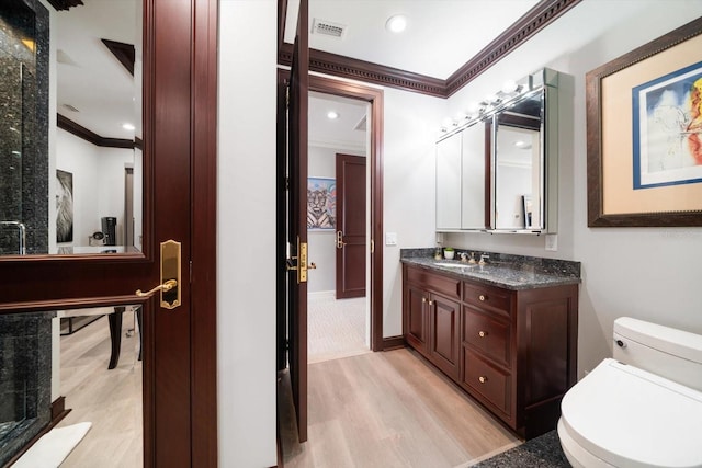 bathroom with vanity, wood finished floors, visible vents, and crown molding